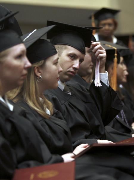 Adam Fox, church music graduate, adjusts his tassel at the fall graduation ceremony. - Photo by Kyle Kurlick