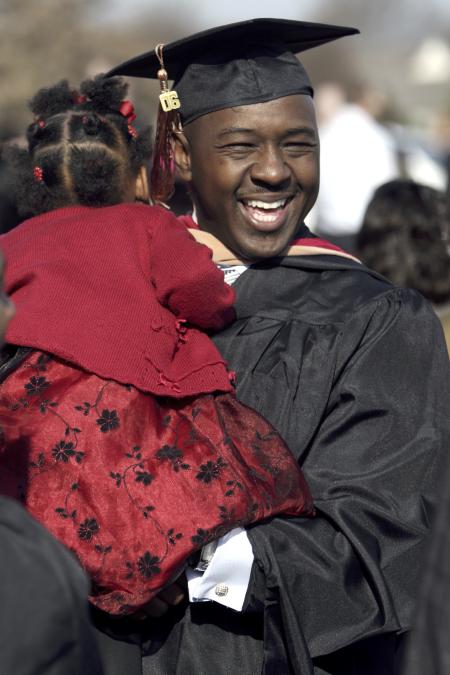 Marlon Heidelberg, MBA graduate, celebrates with his daughter Mackenzie while greeting friends and family after fall graduation. - Photo by Kyle Kurlick