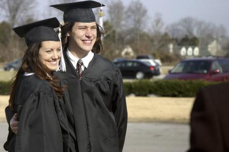 Jenni Betts and Chris Deming smile as family members take pictures of them after the fall graduation ceremony. - Photo by Stephanie Schroeder