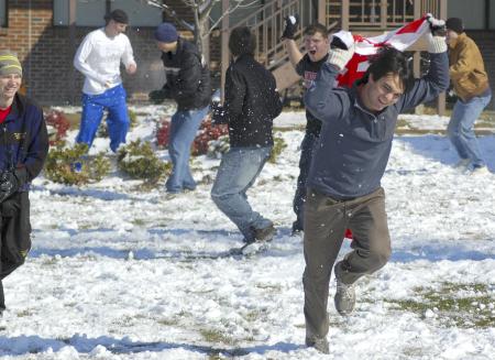 Junior Cody Curtis, music major, gets barraged by snowballs during a snowball fight in the McAfee residence complex. - Photo by Matthew Diggs