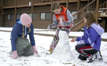 Senior Katie Watson, ESL major, helps Isaac and Anna Elliott, children of McAfee resident director Kelly Elliott, to build a snowman. - Photo by Matthew Diggs