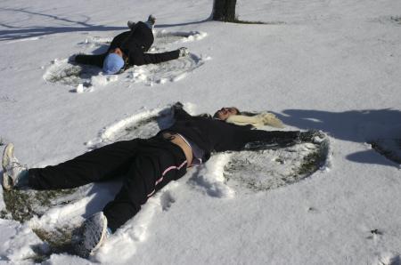 Hanna Bisset and Rebekah Frost create snow angels during a rare snow day that was the result a few inches of snow the came to campus. - Photo by Stephanie Schroeder