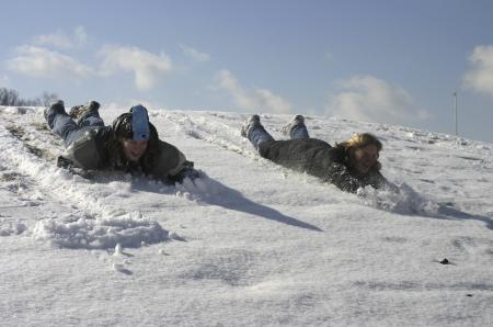 Hannah Hocutt and Hanna Bisset attempt to slide down face forward on a hill found on campus during a snow day. - Photo by Stephanie Schroeder