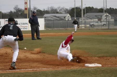 Bulldog Shaun Cozart safely slides into third base as Mark Peterson from Southern Viriginia University leaps to catch the ball. Cozart later made it home adding another run. The Bulldogs finished the game with an 8-3 victory.  - Photo by Stephanie Schroeder