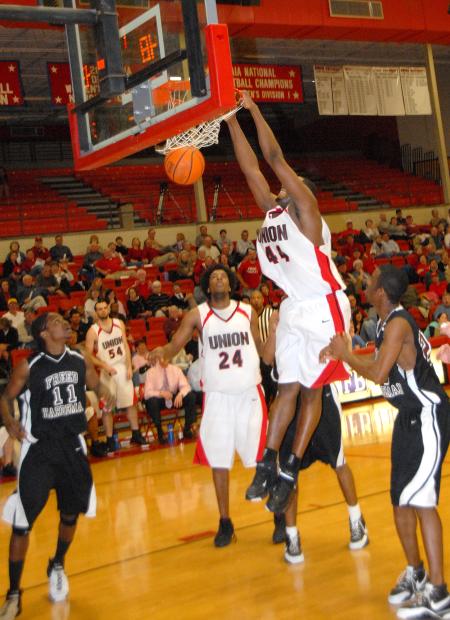 Senior center Pierry Valmera completes a dunk in Union 76-58 win over Freed-Hardeman in the quarterfinals of the TranSouth Conference Tournament. - Photo by Morris Abernathy