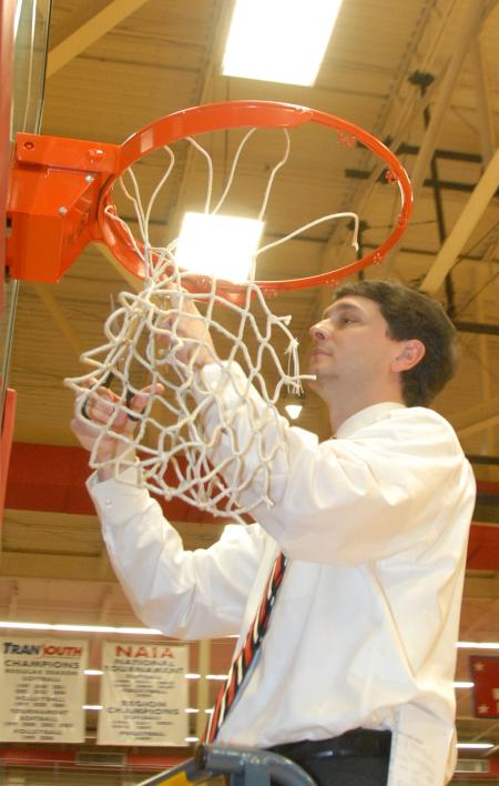 Head Coach Mark Campbell cuts down the nets after the Lady Bulldog's TranSouth Tournament Championship win. - Photo by Morris Abernathy