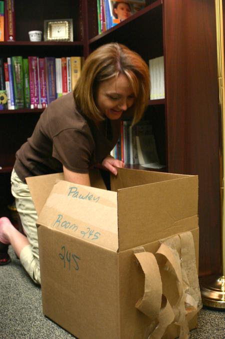 Christie Pawley, instructor of nursing, unpacks the last of her boxes in her new office in White Hall. - Photo by Stephanie Schroeder