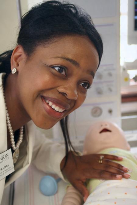 Renee Jones of career services receives some shock and amazement while feeling the nursing department's baby simulator during a demonstration at the White Hall dedication. - Photo by Kyle Kurlick