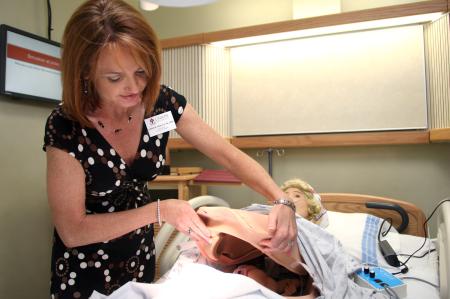 Christie Pawley demonstrates the inside of the birthing simulator at the White Hall dedication. - Photo by Kyle Kurlick