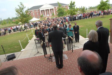 Richard Joiner, chair of the music department, leads the White Hall dedicaiton crowd in the hymn of celebration <em>To God Be the Glory</em>. - Photo by Morris Abernathy