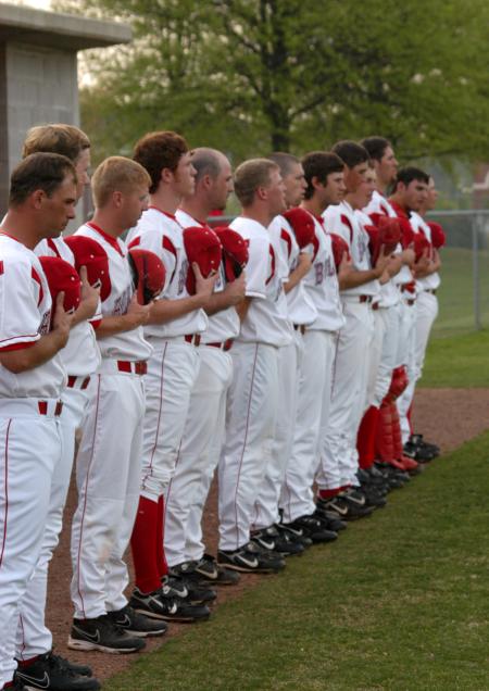 Union coaches and players stand during the National Anthem. - Photo by Steven Aldridge