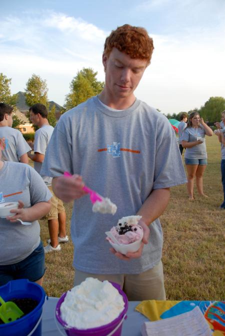 Tyler Jackson adds some whipped cream to his ice cream at the Ice Cream Social at President Dockery's home. - Photo by Morris Abernathy