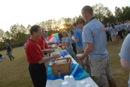 Gary Carter and Tim Smith serve ice cream to incoming freshmen at President Dockery's house for the annual ice cream social. - Photo by Morris Abernathy