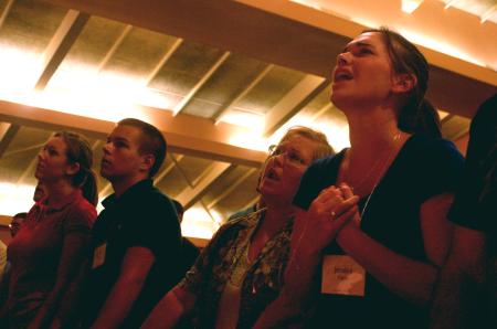 Jessica Yates and her family sings along during the family chapel on the first day of orientation. - Photo by Stephanie Schroeder
