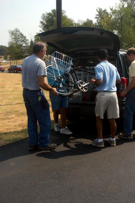 James Williams, a facilities management worker, Bobby Allen and Sam Chhim, both from Poplar Heights Baptist Church, help Mark Gage unload his daughter's bike. Gage and his daughter, Laura Gage, an undeclared major, are from Soddy Daisy, Tenn. - Photo by Stephanie Schroeder