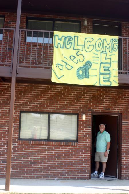 Tommy Holden peeks out the door below a sign welcoming girls to Lee for their first year. Holden's daughter Amy, an elementary education major, and her family are from Germantown, Tenn. - Photo by Stephanie Schroeder