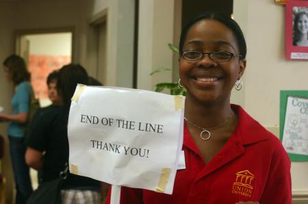 Reneé Jones of career services holds a sign up for students to know where exactly the end of the line is as she stands in the McAfee commons. - Photo by Stephanie Schroeder