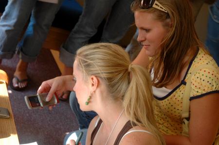 Focus Leader Elizabeth Wood looks at pictures on Freshman Chemistry Major Ashley Pugh's cell phone. - Photo by Neisha Fuson