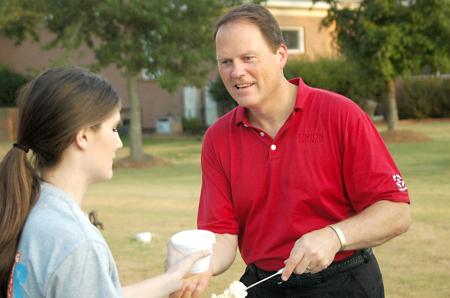 Gary Carter, senior vice president for business and financial services, serves ice cream to new students at an ice cream social held at the home of President Dockery.  - Photo by Matthew Diggs