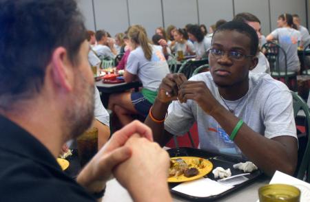 Nigerian Toyin Adedokun talks with Jan Wilms, computer science department chair, during the Dinner with your Department event at New Student Orientation. - Photo by Stephanie Schroeder