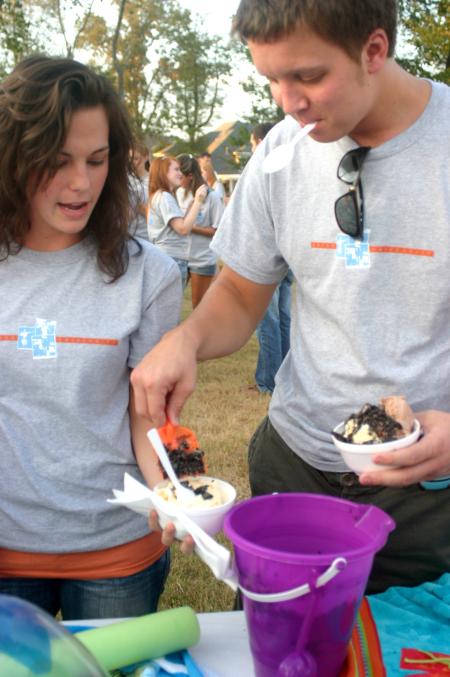 Freshmen Hannah Harvell, an MK from the Phillipines, and Trey Wilcox spread chocolate chips on their ice cream during the annual ice cream social at the home of President Dockery. - Photo by Stephanie Schroeder
