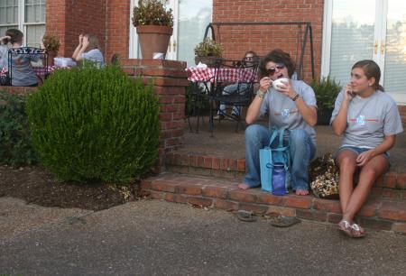 Jana Lawson, a Spanish TESL major from Memphis, enjoys some ice cream in President Dockery's backyard as her friend and fellow freshman Erin Liddle, an art major from Memphis, looks on. - Photo by Stephanie Schroeder