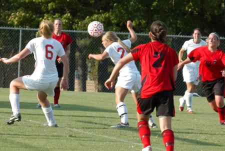 Caitlin Clinger heads the ball as teammate Sam Gase reacts to the ball and Nikki Burau follows behind. - Photo by Steven Aldridge
