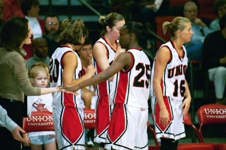 Junior Chrystal Merriweather (25) gets congrats from teammates Laura Davison, Peggy McCain, Laura Mitchell, and student assistant Cherry Johnson. - Photo by Justin Veneman