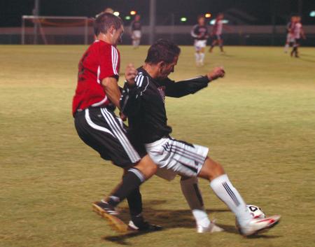 Senior Kyle Sanders uses some fancy footwork as he tries to keep the ball from his opponent from Martin Methodist College. - Photo by Neisha Fuson