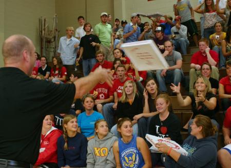 Union men's basketball coach Ralph Turner passes out pizza to the students during Bulldog Madness. - Photo by Stephanie Schroeder