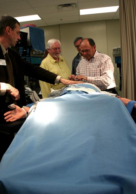 Alums were able to test the simulator mannequin under Mark Kossick's instruction at the School of Nursing's homecoming reception. - Photo by Kristi McMurry Woody