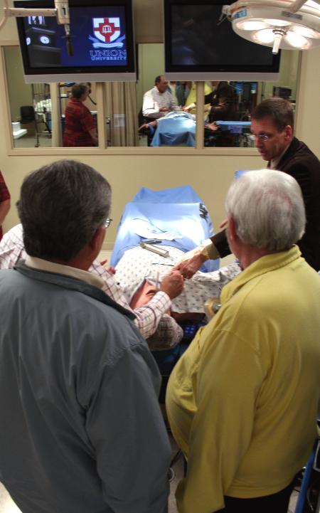 Mark Kossick describes the new simulation technology during a tour of the simulation lab at the School of Nursing's homecoming reception. - Photo by Kristi McMurry Woody