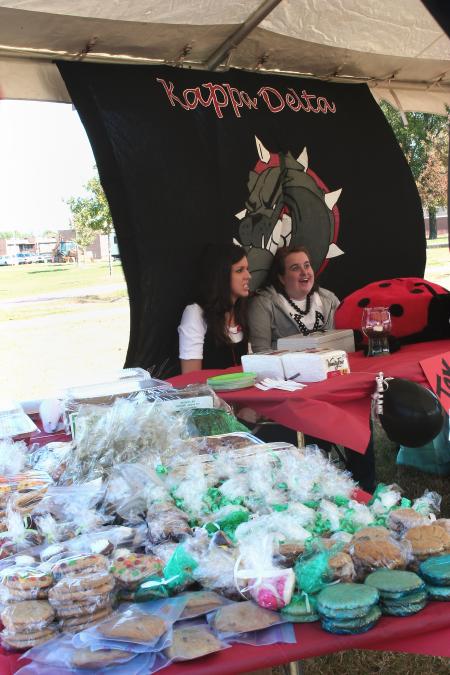 Katherine Kipp, junior English major, and Kristen Fabrizio, sophomore history major, sell baked goods at the Kappa Delta booth during Homecoming's Arts in the Park. - Photo by Kristi McMurry Woody