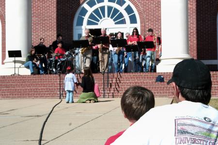 Blake Ward and his son of Jackson enjoyed watching the reunion band play in front of Jennings Hall during Homecoming's Arts in the Park. - Photo by Kristi McMurry Woody