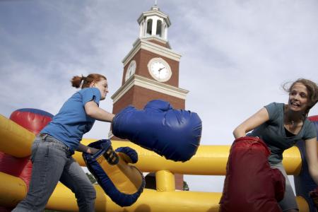 Kinsey Bolinger and Emily Watlington enjoy May Day by boxing in the inflatable ring set up for students on the great lawn by Miller Tower. - Photo by Kyle Kurlick