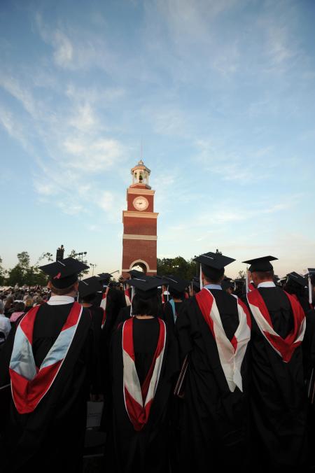 Students rise at the conclusion of the Spring Commencement Service. Miller Tower stands in the background, still showing some damage from the Feb. 5 tornado. - Photo by Morris Abernathy