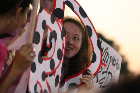 Kelsey Nagy, sophomore art major, holds up the D in the K-Brad sign that she helped make for her Life Group leader Kevin Bradley during a soccer match. - Photo by Kristi McMurry Woody