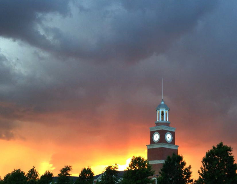 Storm clouds roll in while the sun sets on Miller Tower at the end of the spring semester.